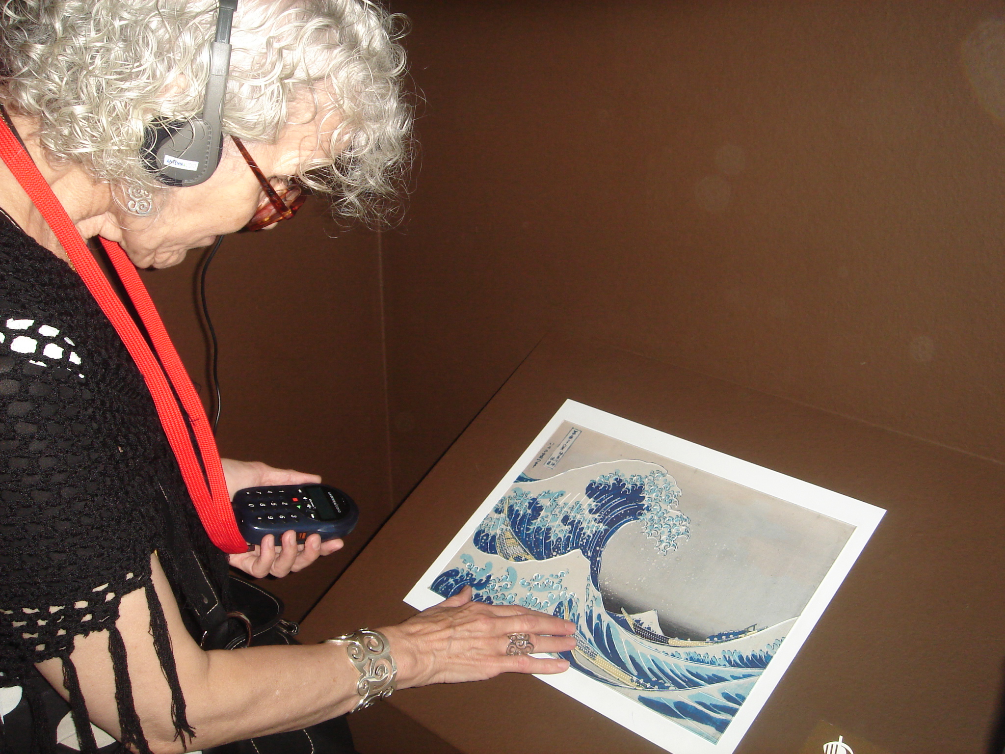 woman following the AD description of a tactile image. Photo: ComAccess